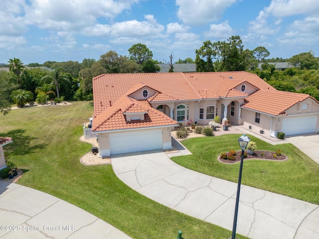 mediterranean / spanish-style home with concrete driveway, a front yard, stucco siding, and a tiled roof