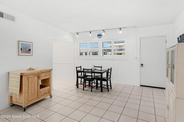 dining area featuring light tile patterned floors and baseboards