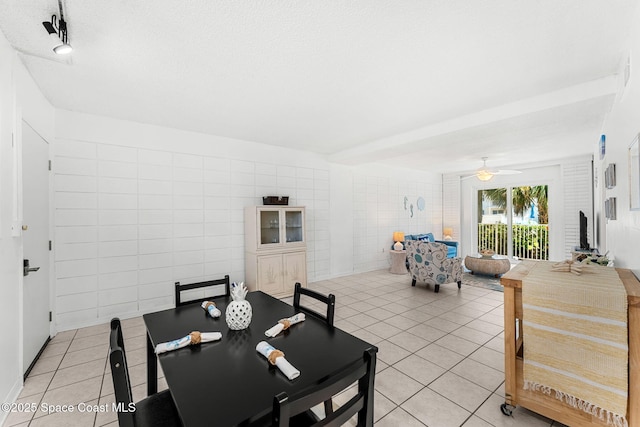 dining space with light tile patterned floors, tile walls, and a ceiling fan