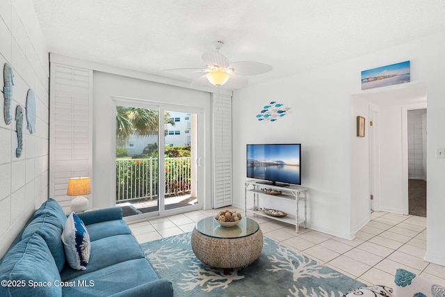 living room featuring ceiling fan, tile patterned flooring, and a textured ceiling
