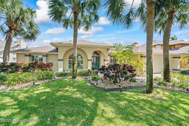 117 Windward Way, Indian Harbour Beach, FL 32937 - view of front of home with a front lawn, an attached garage, and stucco siding