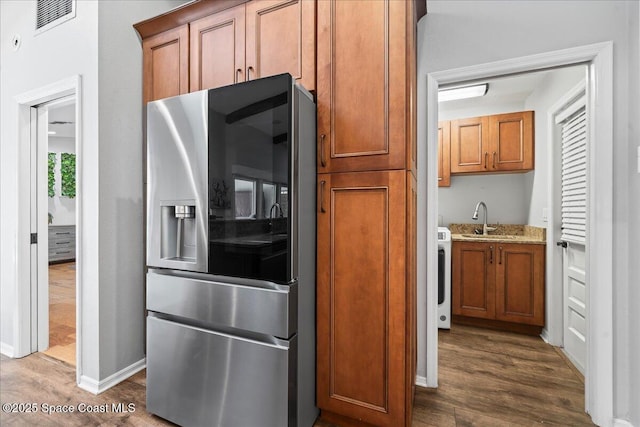 117 Windward Way, Indian Harbour Beach, FL 32937 - kitchen featuring brown cabinetry, a sink, visible vents, stainless steel refrigerator with ice dispenser, and dark wood-type flooring