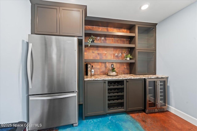 117 Windward Way, Indian Harbour Beach, FL 32937 - bar with wine cooler, concrete floors, baseboards, a dry bar, and freestanding refrigerator
