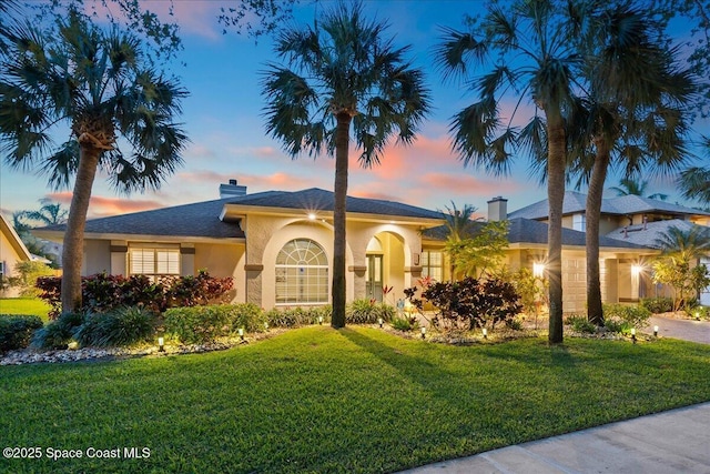 117 Windward Way, Indian Harbour Beach, FL 32937 - ranch-style house featuring stucco siding, a chimney, and a front lawn