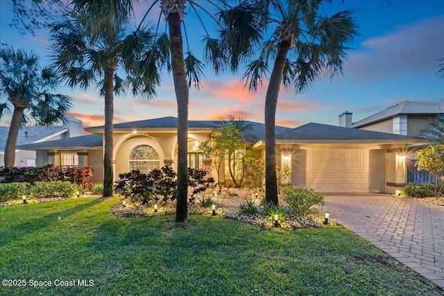 117 Windward Way, Indian Harbour Beach, FL 32937 - view of front of home featuring a lawn, driveway, stucco siding, and a garage
