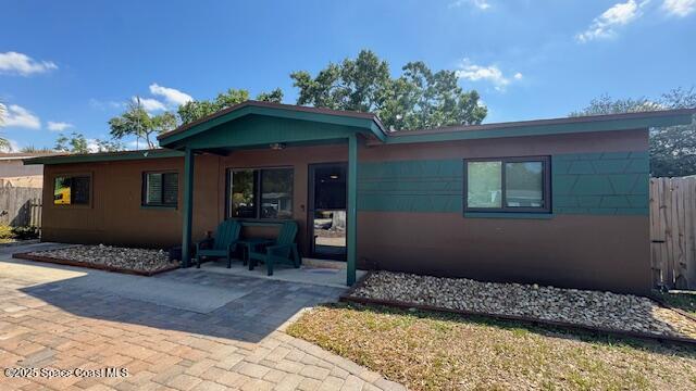 view of front of house with fence and a patio area