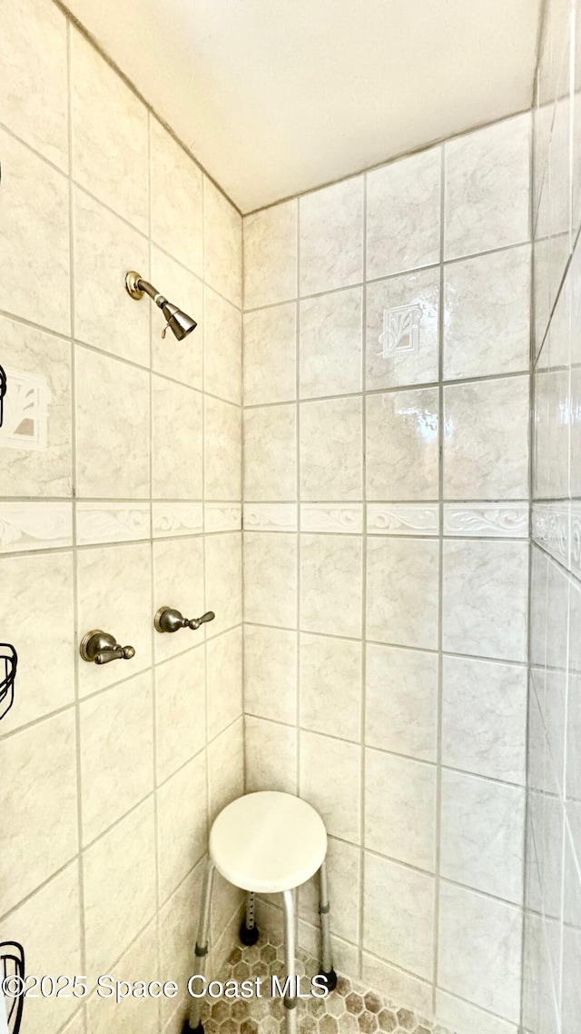 full bath featuring tile patterned floors and tiled shower