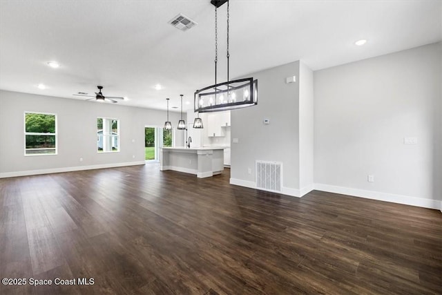 unfurnished living room featuring a ceiling fan, visible vents, recessed lighting, and dark wood-type flooring
