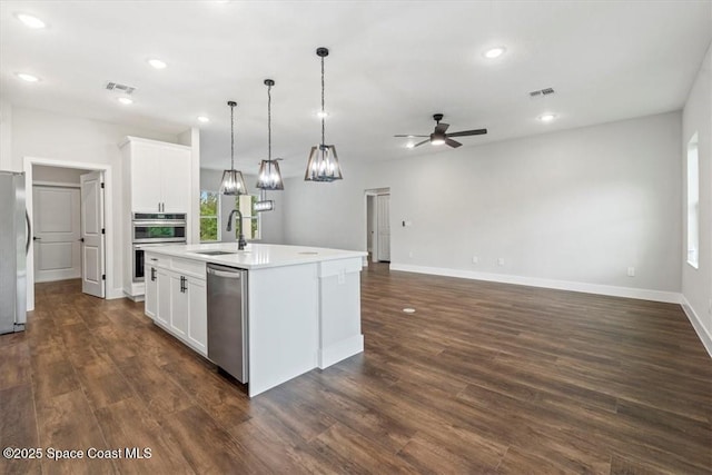 kitchen with visible vents, a sink, a center island with sink, appliances with stainless steel finishes, and ceiling fan