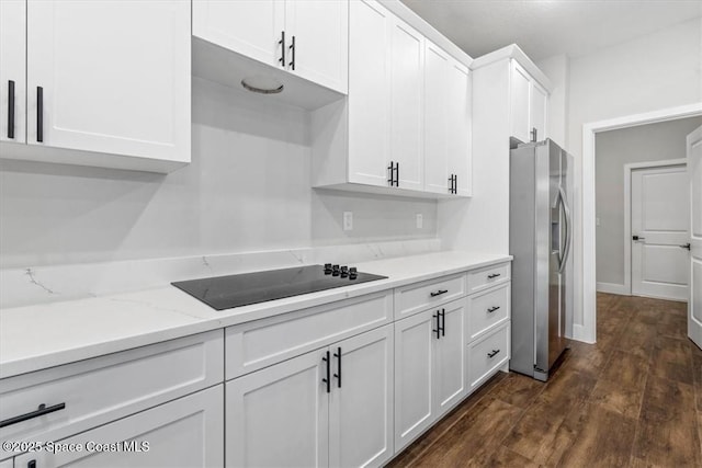 kitchen featuring black electric cooktop, white cabinetry, light stone counters, stainless steel refrigerator with ice dispenser, and dark wood-type flooring