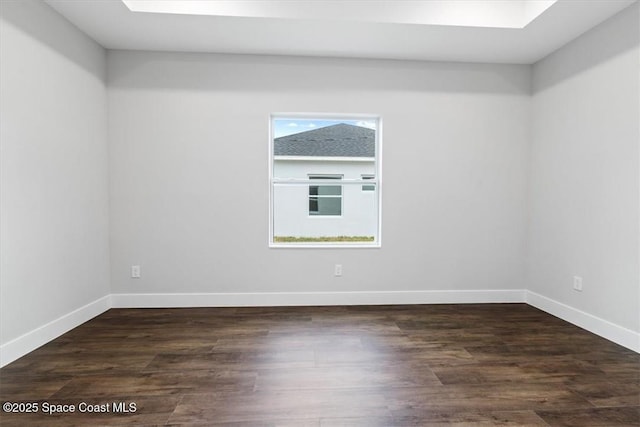 unfurnished room with baseboards, dark wood-type flooring, and a healthy amount of sunlight
