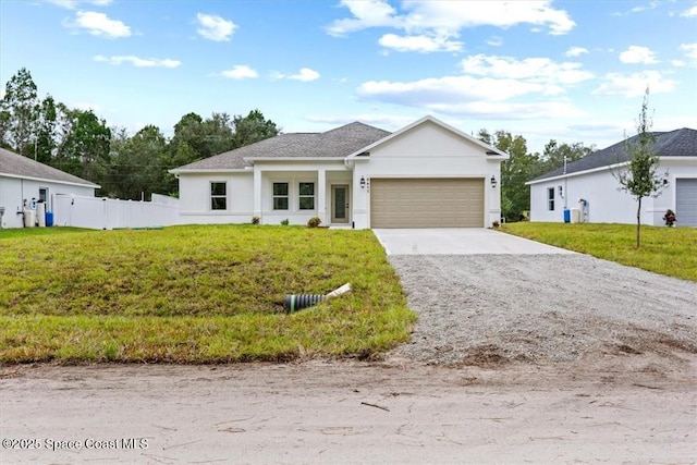 view of front of home with an attached garage, driveway, fence, and a front yard