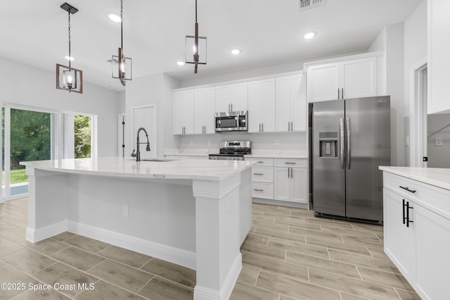 8276 100th Ave, Vero Beach, FL 32967 - kitchen featuring stainless steel appliances, white cabinets, an island with sink, and recessed lighting