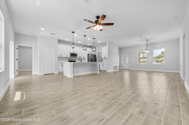 8276 100th Ave, Vero Beach, FL 32967 - unfurnished living room with recessed lighting, a ceiling fan, and light wood-style floors