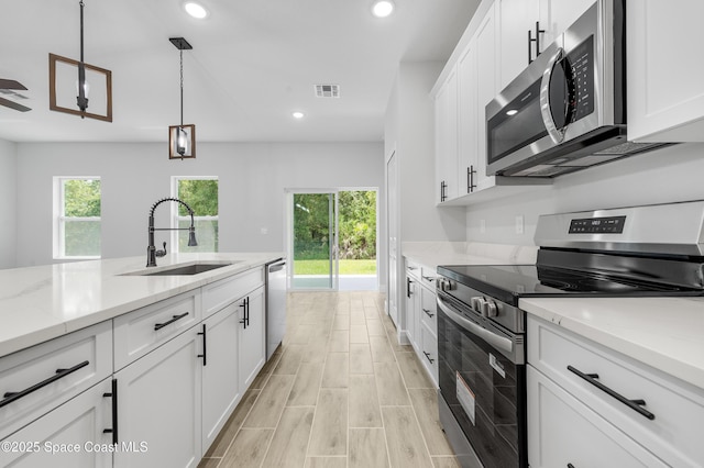 8276 100th Ave, Vero Beach, FL 32967 - kitchen featuring appliances with stainless steel finishes, recessed lighting, white cabinetry, pendant lighting, and light stone countertops