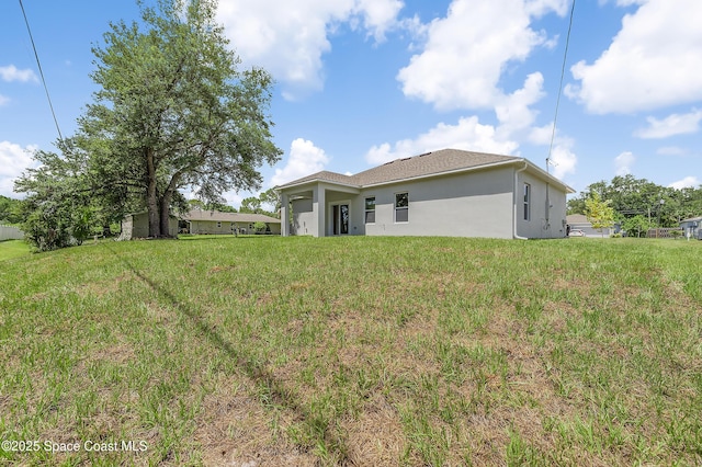 8276 100th Ave, Vero Beach, FL 32967 - back of property with stucco siding and a yard