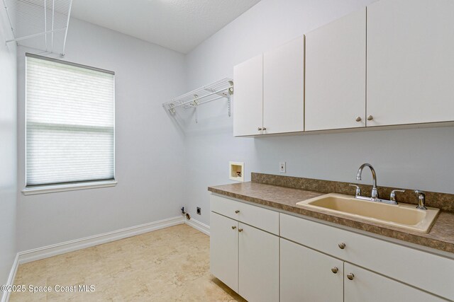4117 Melrose Ct, Melbourne, FL 32940 - washroom featuring hookup for an electric dryer, washer hookup, a sink, baseboards, and cabinet space