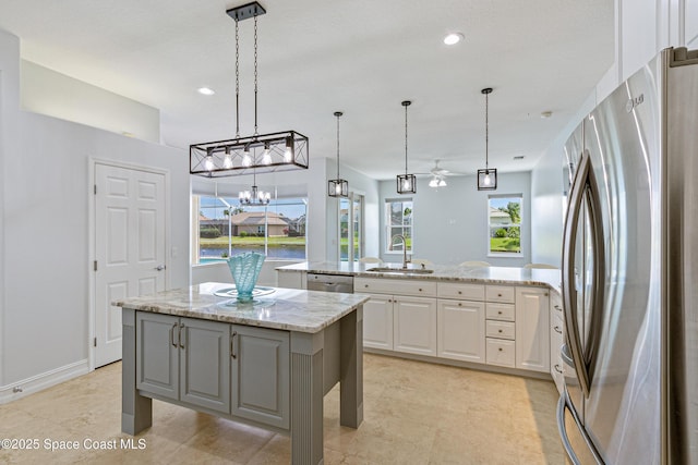 4117 Melrose Ct, Melbourne, FL 32940 - kitchen with white cabinetry, a sink, freestanding refrigerator, a center island, and a peninsula