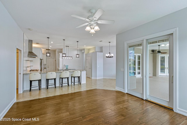 4117 Melrose Ct, Melbourne, FL 32940 - unfurnished living room featuring recessed lighting, baseboards, wood finished floors, and ceiling fan with notable chandelier