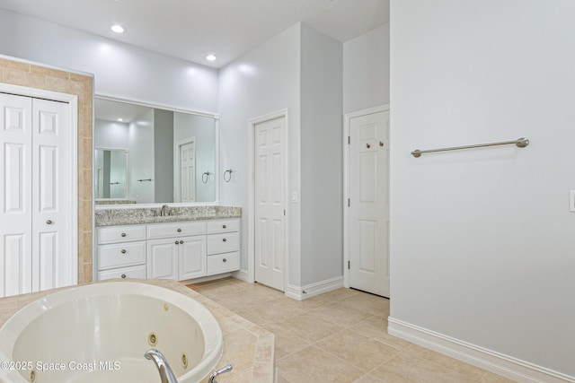 4117 Melrose Ct, Melbourne, FL 32940 - bathroom featuring baseboards, a closet, a tub with jets, vanity, and tile patterned flooring