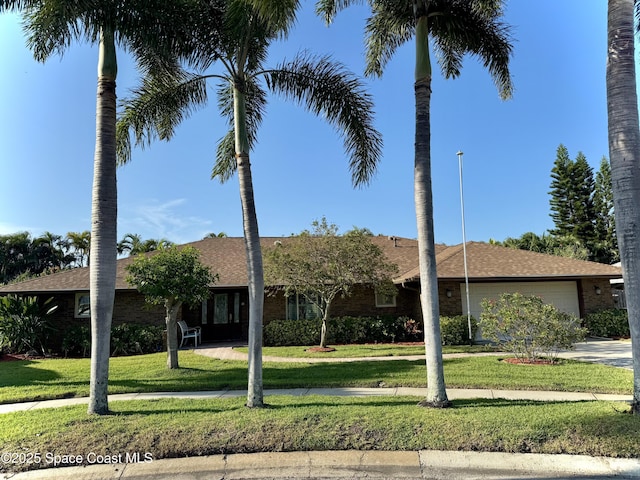 single story home featuring driveway, a front lawn, and an attached garage