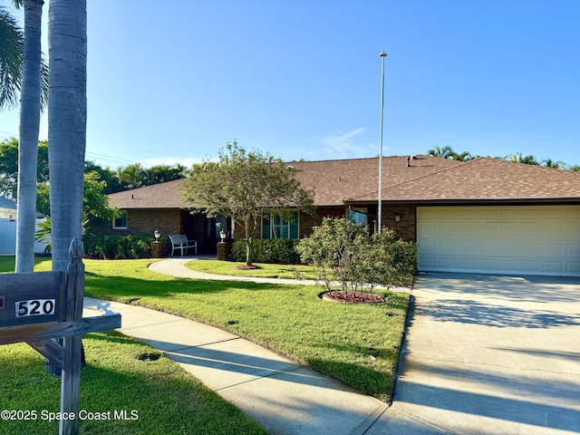 ranch-style house with a front yard, a garage, a shingled roof, brick siding, and concrete driveway
