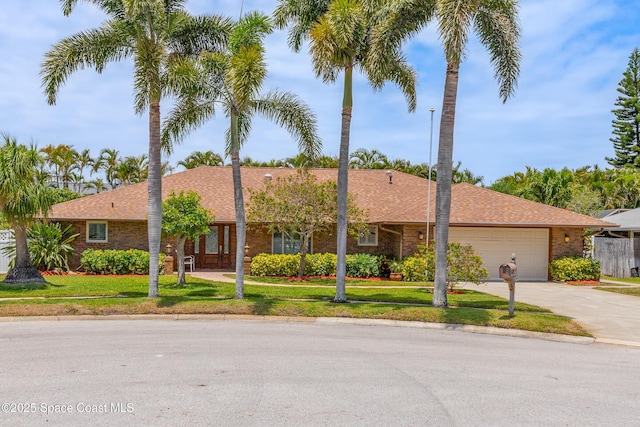 ranch-style house featuring a garage, concrete driveway, brick siding, and a front yard