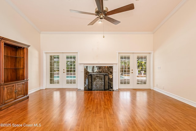 unfurnished living room with french doors, crown molding, and ceiling fan