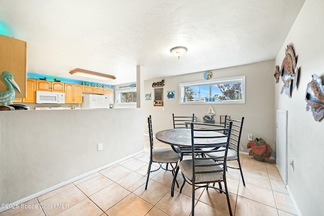 dining room with baseboards and light tile patterned floors