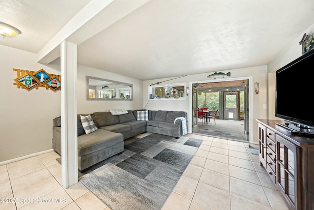 living area featuring baseboards and light tile patterned flooring