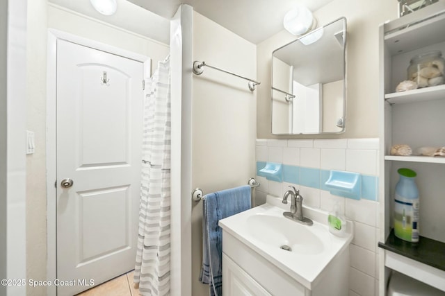 bathroom with a shower with curtain, vanity, tile patterned floors, and tile walls