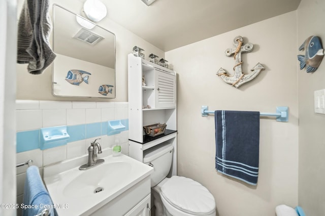 bathroom featuring visible vents, toilet, and vanity