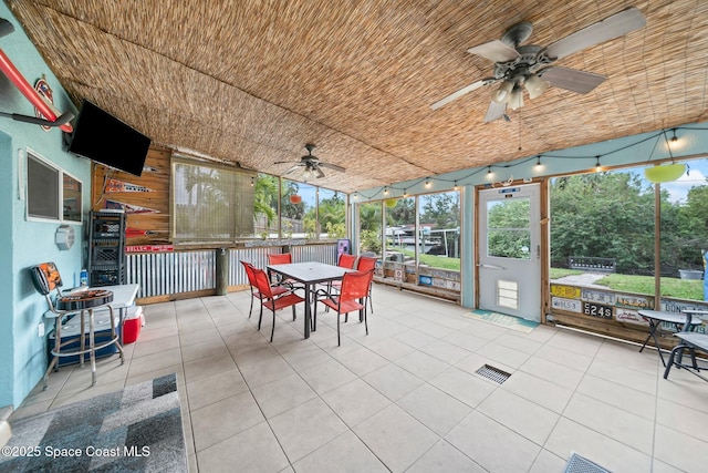 sunroom / solarium with a ceiling fan and outdoor dining space