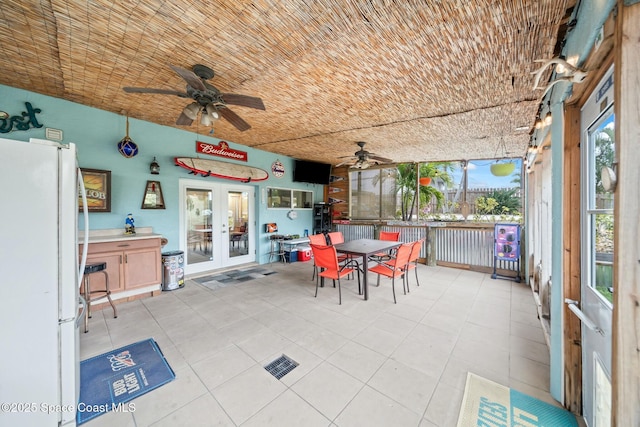 sunroom featuring ceiling fan and french doors