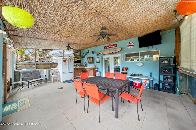 tiled dining room featuring french doors and ceiling fan