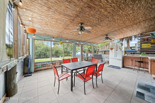 sunroom / solarium with ceiling fan, outdoor dining area, and exterior kitchen