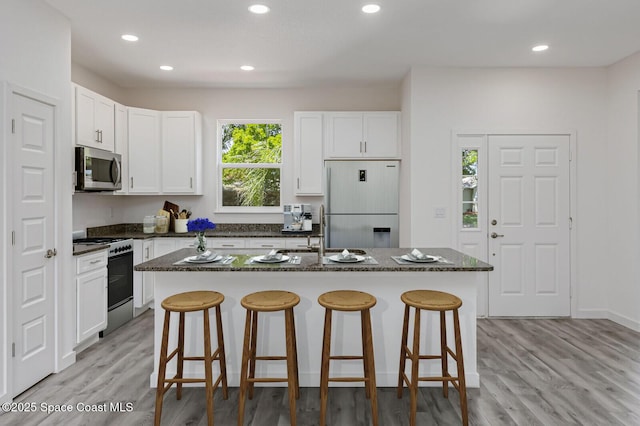 958 Chace Ln NE, Palm Bay, FL 32905 - kitchen with refrigerator, stainless steel microwave, a sink, a kitchen breakfast bar, and range with gas cooktop
