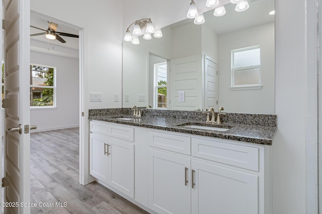 958 Chace Ln NE, Palm Bay, FL 32905 - full bath with double vanity, a sink, ceiling fan, and wood finished floors