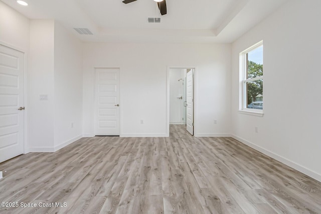958 Chace Ln NE, Palm Bay, FL 32905 - unfurnished bedroom featuring visible vents, light wood-type flooring, a tray ceiling, and baseboards