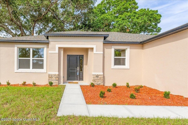 958 Chace Ln NE, Palm Bay, FL 32905 - doorway to property with stucco siding, stone siding, and roof with shingles