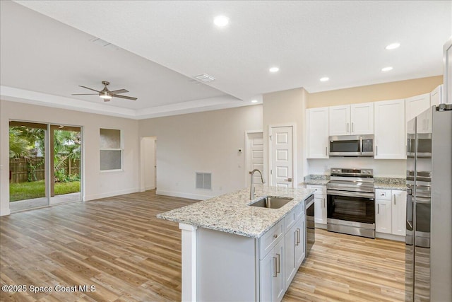 958 Chace Ln NE, Palm Bay, FL 32905 - kitchen with stainless steel appliances, a ceiling fan, light wood-type flooring, a center island with sink, and recessed lighting