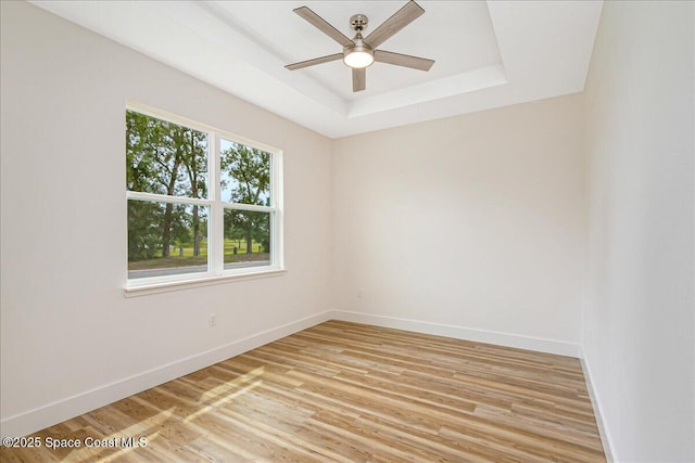 958 Chace Ln NE, Palm Bay, FL 32905 - spare room with light wood finished floors, ceiling fan, and a tray ceiling