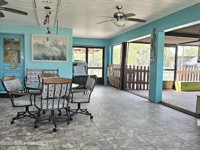 sunroom featuring a ceiling fan and outdoor dining space