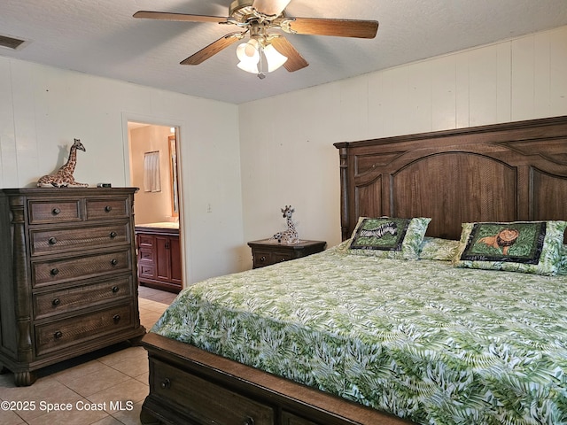 bedroom with light tile patterned flooring, connected bathroom, and ceiling fan