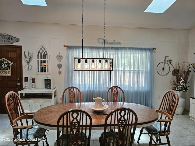 dining area featuring a skylight and light tile patterned floors