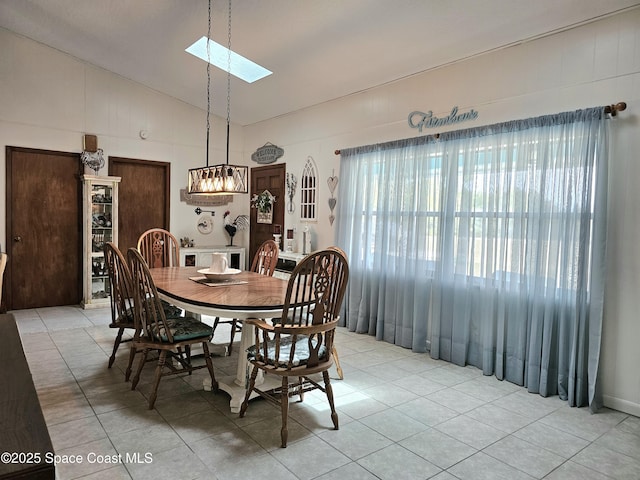 dining space with a skylight, light tile patterned floors, and high vaulted ceiling