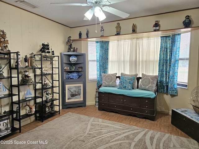 sitting room with a ceiling fan and baseboards