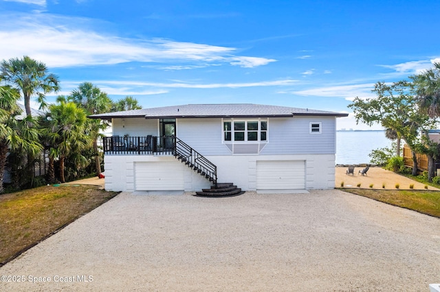 860 S Banana River Dr, Merritt Island, FL 32952 - view of front of property with brick siding, an attached garage, driveway, and stairs