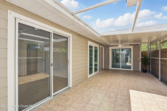 unfurnished sunroom with a ceiling fan
