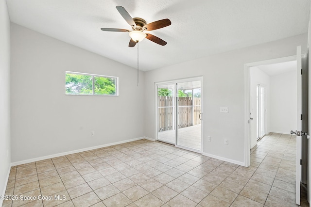 spare room featuring a ceiling fan, baseboards, vaulted ceiling, and light tile patterned floors